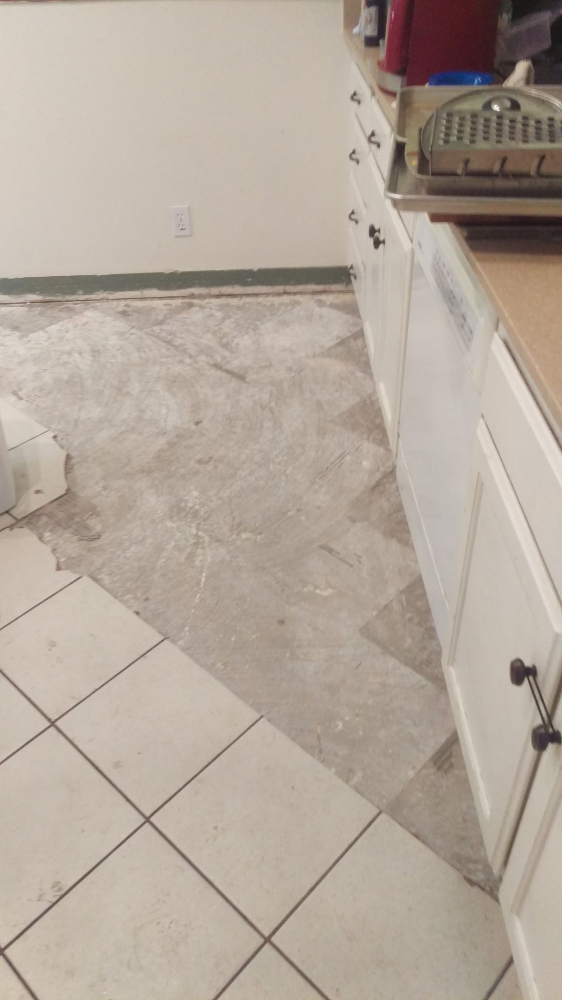 Subfloor exposed along the cabinets